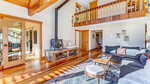 Un espacio habitable amplio con piso de madera, un sofá, una mesa de centro y una chimenea.