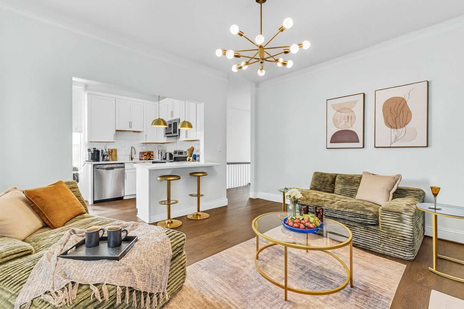 A modern living room with a sofa, coffee table, and a kitchen area in the background.