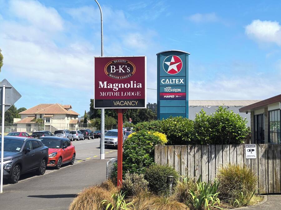 Un senyal de motel per a B-K's Magnolia Motor Lodge i un senyal de gasolinera Caltex.