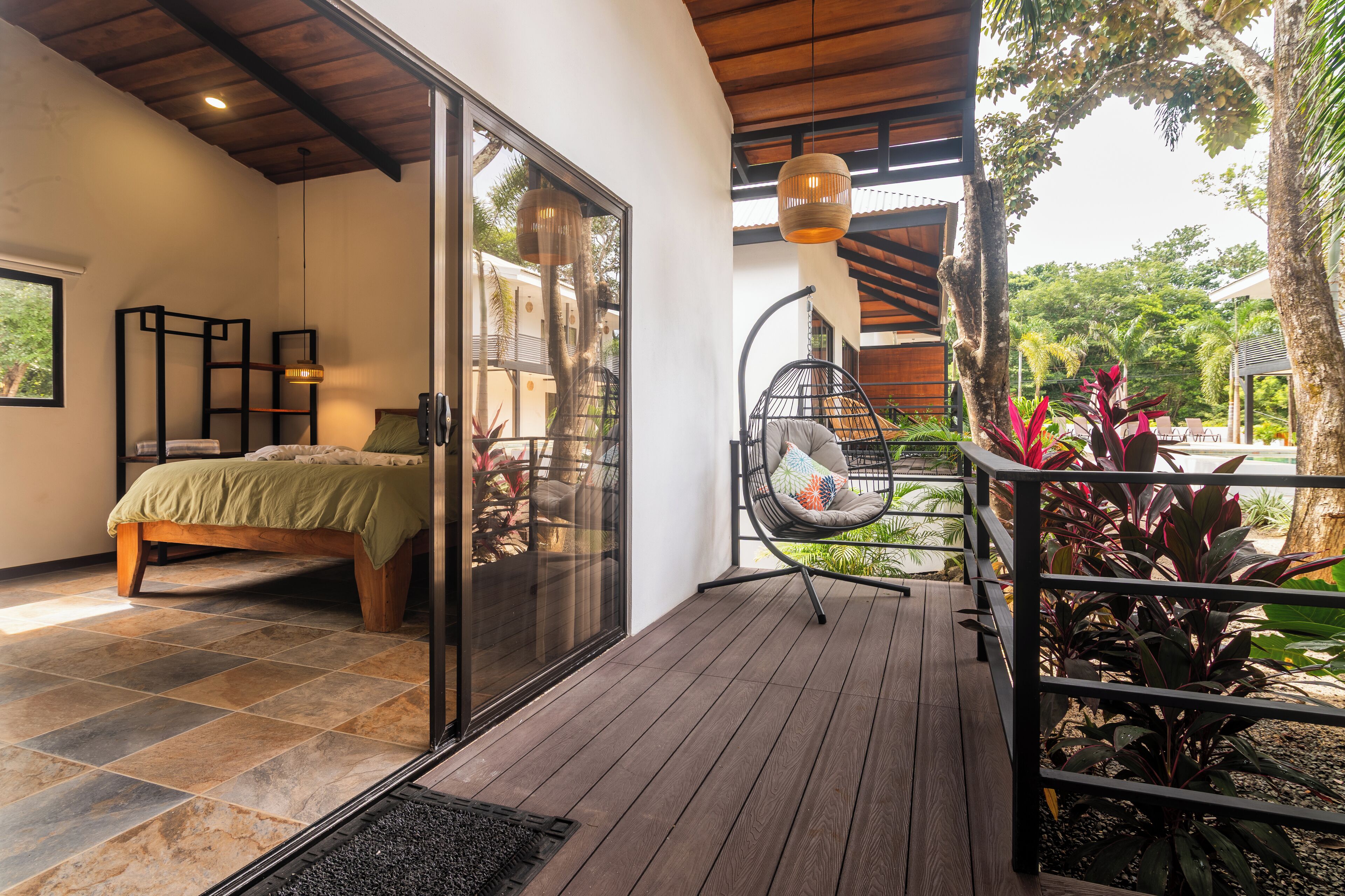 Un dormitorio con cama, una silla y vistas al exterior.