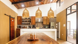 Una cocina moderna con armarios de madera, una isla central y lámparas colgantes.