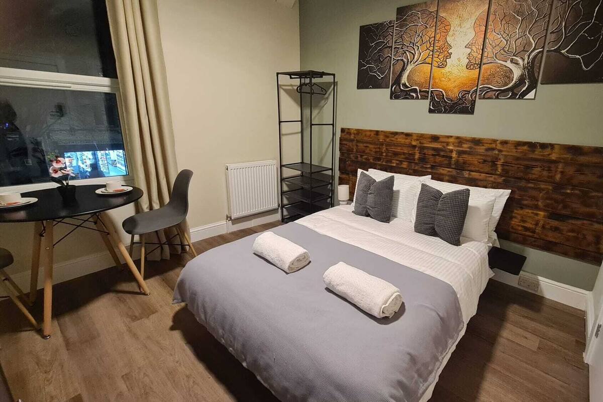 A hotel room with a bed, a desk, and a chair.