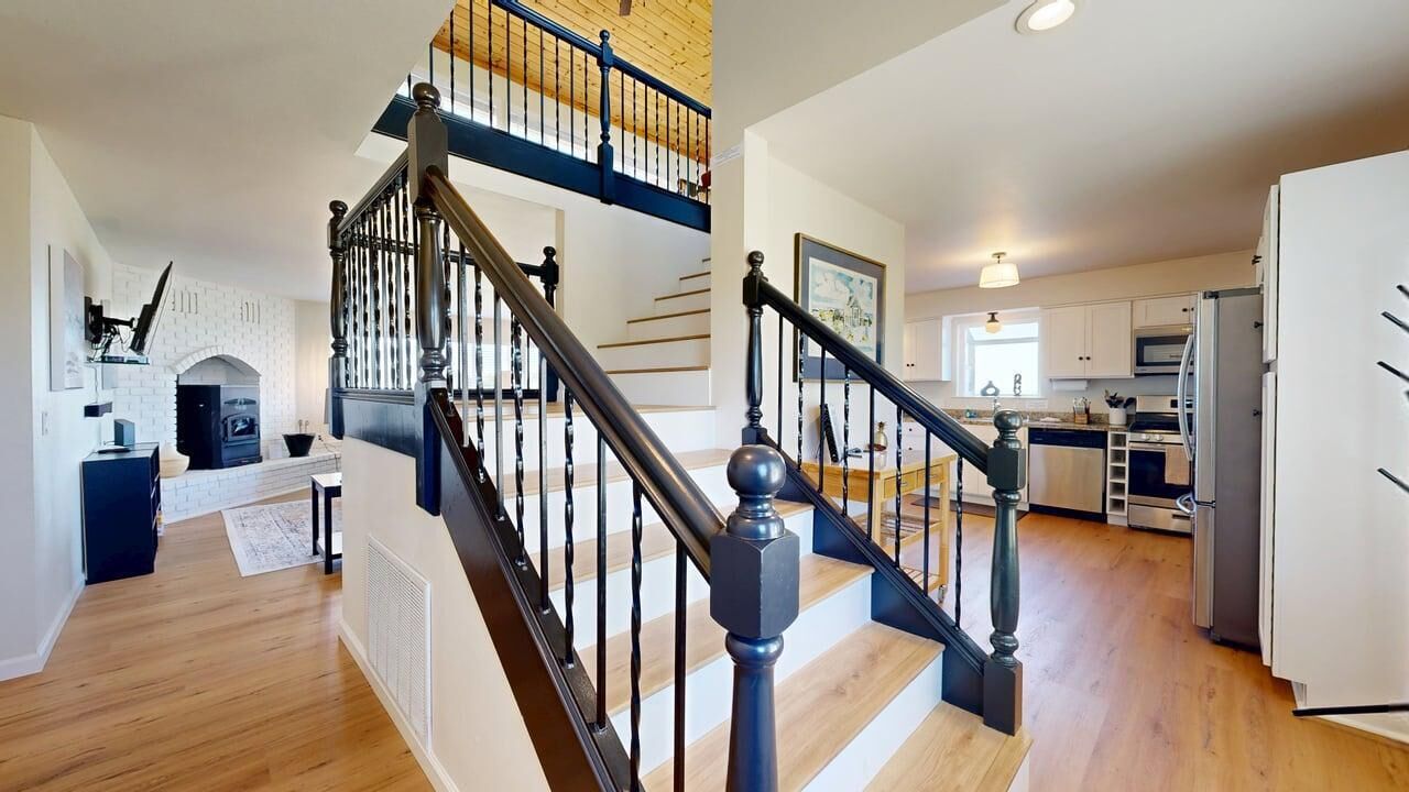 Une cuisine moderne avec des armoires blanches, un four encastré et un réfrigérateur.
