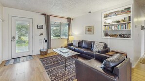 Una sala de estar moderna con un sofá, una mesa de centro y una estantería.