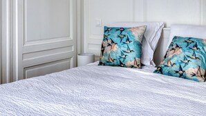 A bedroom with a bed, pillows, and a nightstand. - Blue Bird, charmant studio avec place de parking ! (Rouen)