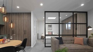 A modern living room with a sofa, a dining table with chairs, and pendant lights. - Treat yourself - luxury inner-city apartment (Dunedin)