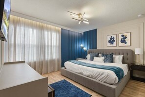 Un dormitorio con cama, cortinas, decoración en la pared y un ventilador de techo.