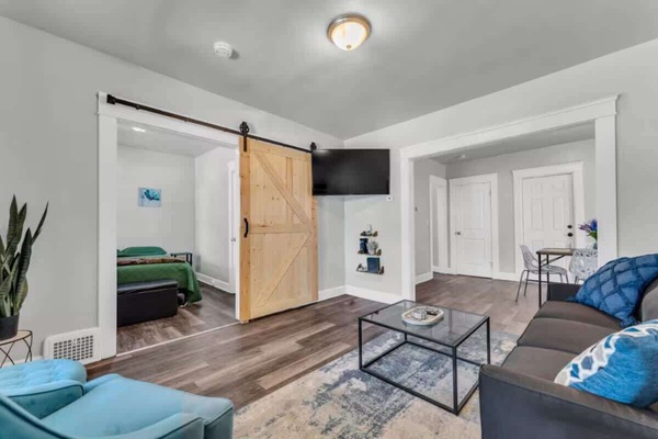 Open living area blending cozy seating & rustic sliding barn door.