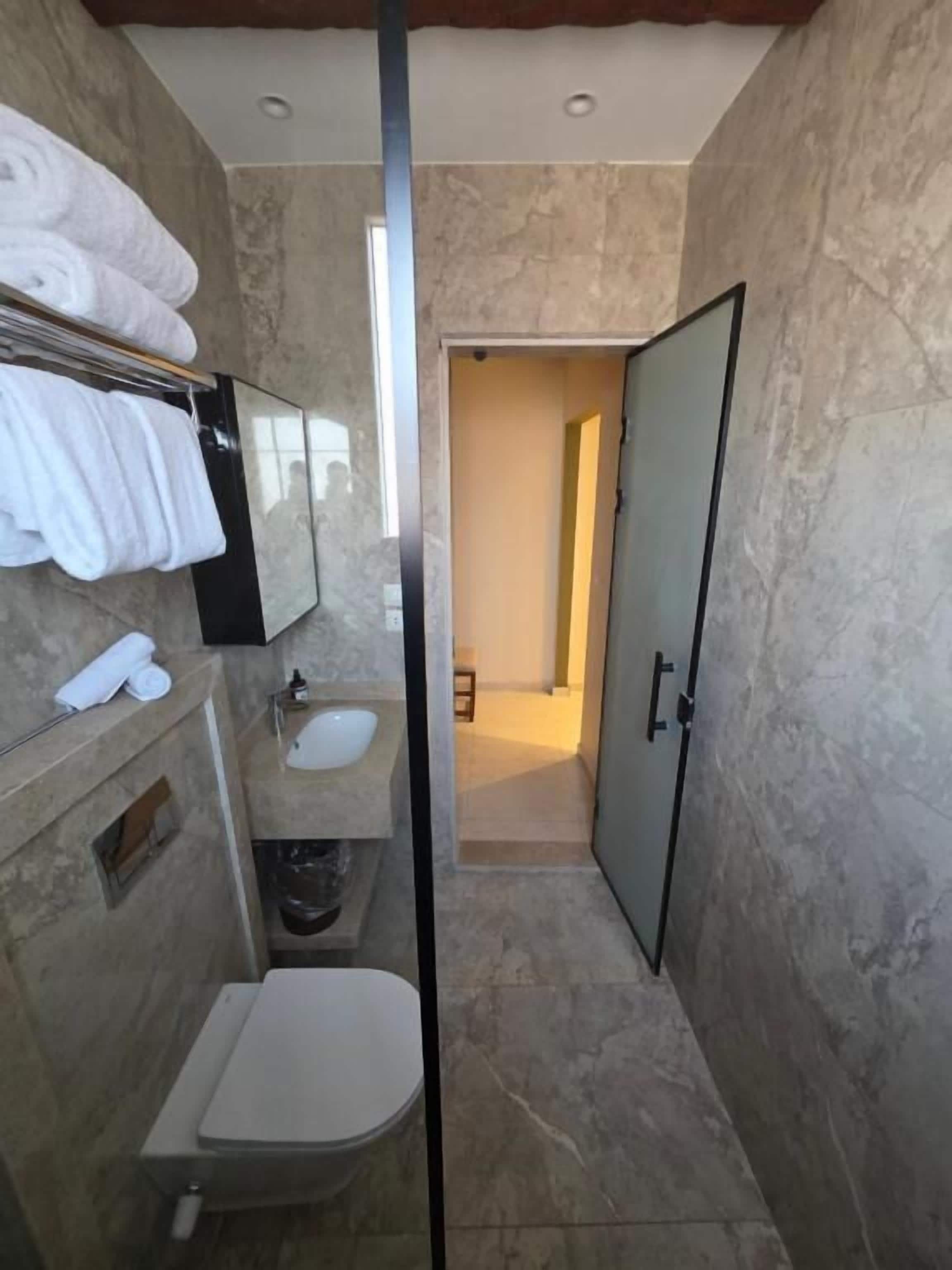 Une salle de bain moderne équipée de toilettes, d’un lavabo et d’un porte-serviettes.