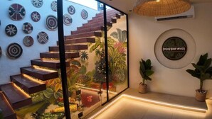 A staircase with a glass enclosure, surrounded by wall-mounted decorative plates, a wall mural, and a circular sign. - Pyramids Spiritual Gate  (Giza)