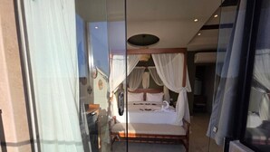 A bedroom with a four-poster bed, a nightstand, and a mirror. - Pyramids Spiritual Gate  (Giza)