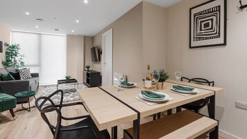 A modern dining area with a wooden table, black chairs, and a minimalist decor.
