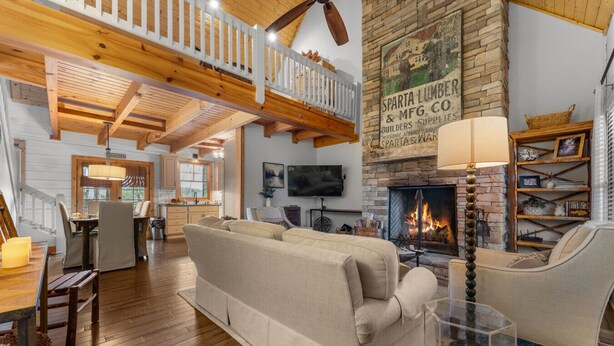 Ein gemütliches Wohnzimmer mit Kamin, Holzböden und hohen Decken.
