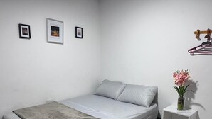 A bedroom with a bed, a nightstand, and a wall-mounted coat rack. - CASAMARTINA (Cartagena)