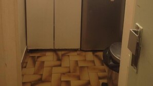 Une cuisine de taille réduite, équipée d’un évier, d’une cuisinière et de placards.
