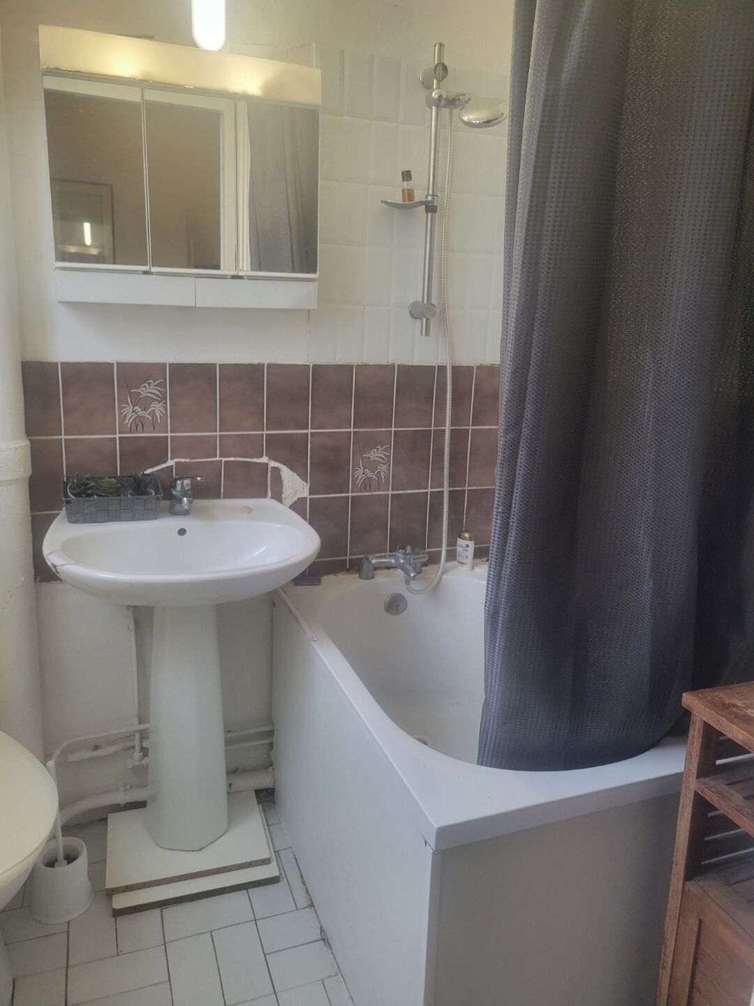 Een badkamer met een wit wastafel, een bad en een douche.