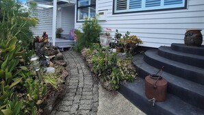 Une maison blanche avec un chemin pavé menant à un escalier.