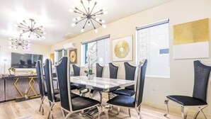 A dining area with a marble table, black upholstered chairs, and modern pendant lighting. - J. Lovely & Spacious 3BR Home by Universal with Patio + Parking (Los Angeles)
