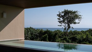 An infinity pool with a view of the ocean and a tree. - Marea Surf Residences: 4BR, Private Pool & Golf Cart (Punta Mita)