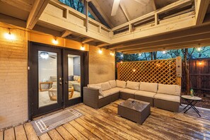An outdoor patio with a sectional sofa, a coffee table, and a wooden deck. - Quiet, peacful, private 4-bedroom house with large backyard and patio space. (Arlington)