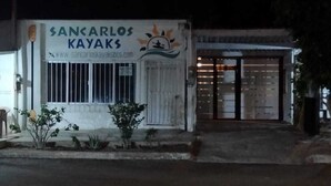 Um edifício com uma placa que diz "SANCARLOS KAYAKS" e um endereço de site.