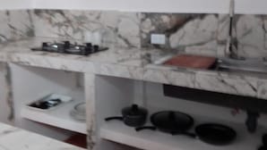 Uma cozinha com bancadas de mármore, fogão a gás e uma pia.