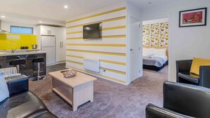 Un espace de vie compact comprenant une kitchenette, un coin repas et une chambre.