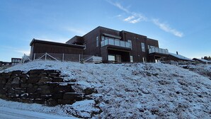 A modern two-story building with a flat roof and large windows. - Stunning apartment in Finnås with house sea view (Finnås)