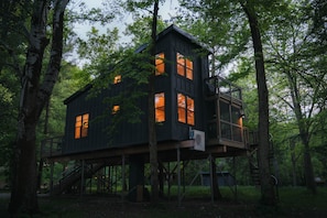 A treehouse with multiple levels, built on stilts, surrounded by dense forest. - Treehouse 1 - Treehouses at Starved Rock (Ottawa)