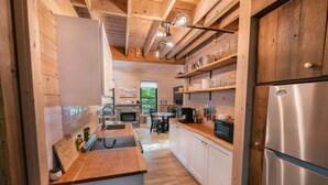 Une cuisine moderne avec des meubles en bois, un réfrigérateur en acier inoxydable et un plan de travail en bois.