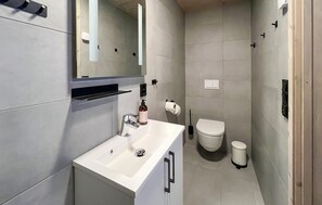 A modern bathroom with a white sink, mirror, and toilet. - Amazing apartment in øyer with WiFi (Øyer)