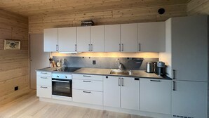Eine moderne Küche mit weißen Schränken, einer Edelstahl-Spüle und einem eingebauten Backofen.