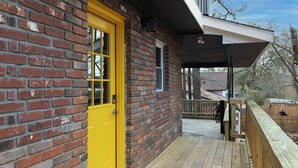 A brick building with a yellow door and a covered porch. - Relaxing ATL Getaway • Modern, Clean & Near City Events, Stadiums, & Attractions (Atlanta)