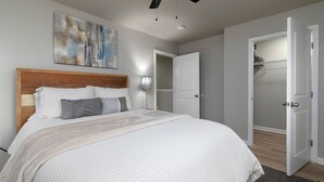A bedroom with a bed, a ceiling fan, a wall-mounted light, and a door leading to a closet. - Relaxing ATL Getaway • Modern, Clean & Near City Events, Stadiums, & Attractions (Atlanta)