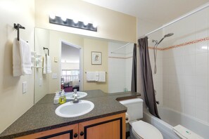 Une salle de bain avec un lavabo, un miroir et une douche.