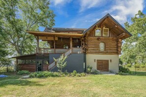 A log cabin with a covered porch, a staircase, and a small front yard. - Lakeside Log Cabin. Hot tub, Dock, Boat Lift! (Manning)