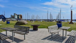 A waterfront park with benches, a large rock, and a statue. - Cozy home in Ystad with sauna (Ystad)