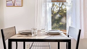 Una tavola imbandita con piatti, bicchieri e posate, affacciata su un panorama alberato.