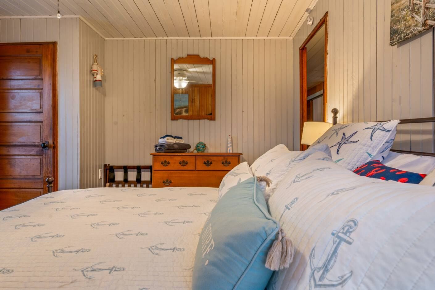 Un dormitorio con cama, cómoda y espejo.