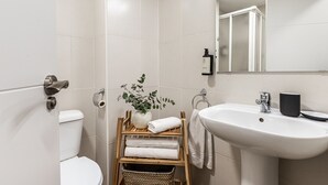 Moderni kylpyhuone, jossa on wc, pesuallas ja peili.