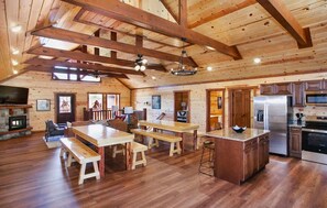 Une cuisine spacieuse avec des poutres en bois, un îlot central et des appareils électroménagers modernes.