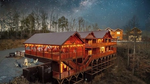 A wooden cabin with a balcony, a deck, and a sign indicating a restaurant. - 8-Bedroom Cabin with Indoor Pool, Outdoor Theater & Hot Tub Near Dollywood (Sevierville)