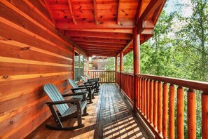 Une terrasse en bois dotée d’une rambarde, de bancs et offrant une vue sur la forêt environnante.