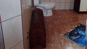 A bathroom with a toilet, sink, and mirror.