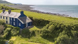 Una casa costera con un jardín amplio y vistas al mar.