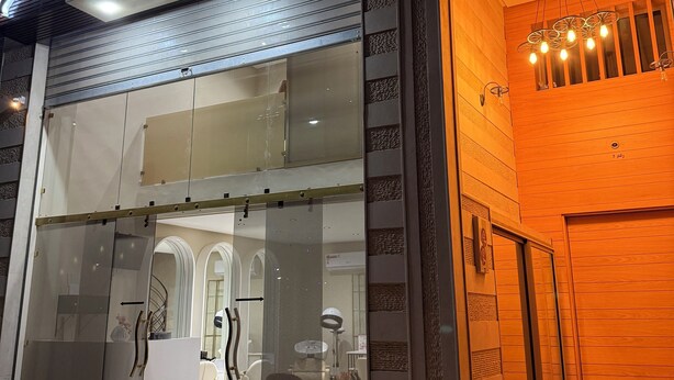 A salon named Glamour Look Studio with a modern glass facade, a visible interior with a reception area, and a wooden entrance with a unique light fixture. - Marrakech 2 Bedroom Brown Luxury Apartment (Marrakech)