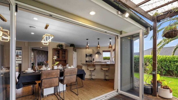 Una cocina moderna con comedor, que incluye un amplio ventanal corredera que da a una terraza.