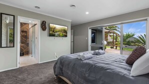 Un dormitorio con cama, ventana grande y vistas al exterior.