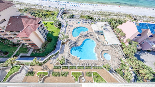 An aerial view of a resort with two swimming pools, a beach, and a parking area. - Exclusive beachfront: 2BR condo, pool, hot tub (Miramar Beach)