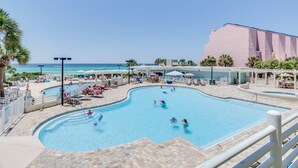 A swimming pool with a view of the ocean, surrounded by lounge chairs and umbrellas. - Exclusive beachfront: Gulf views, sleeps 6 (Miramar Beach)